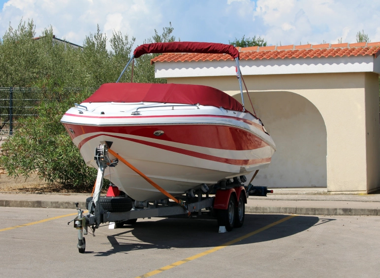 Red and white speedboat on trailer