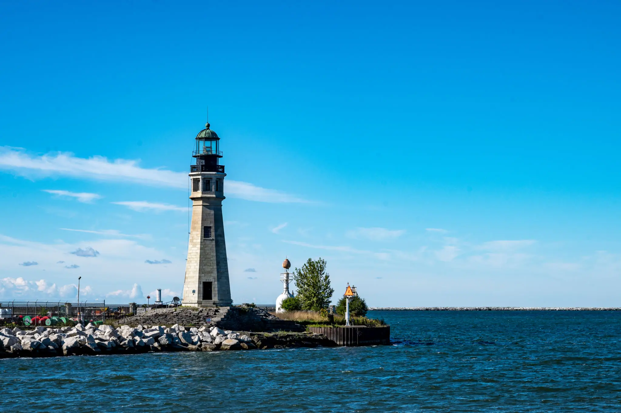 Lighthouse on rocky breakwater by sea