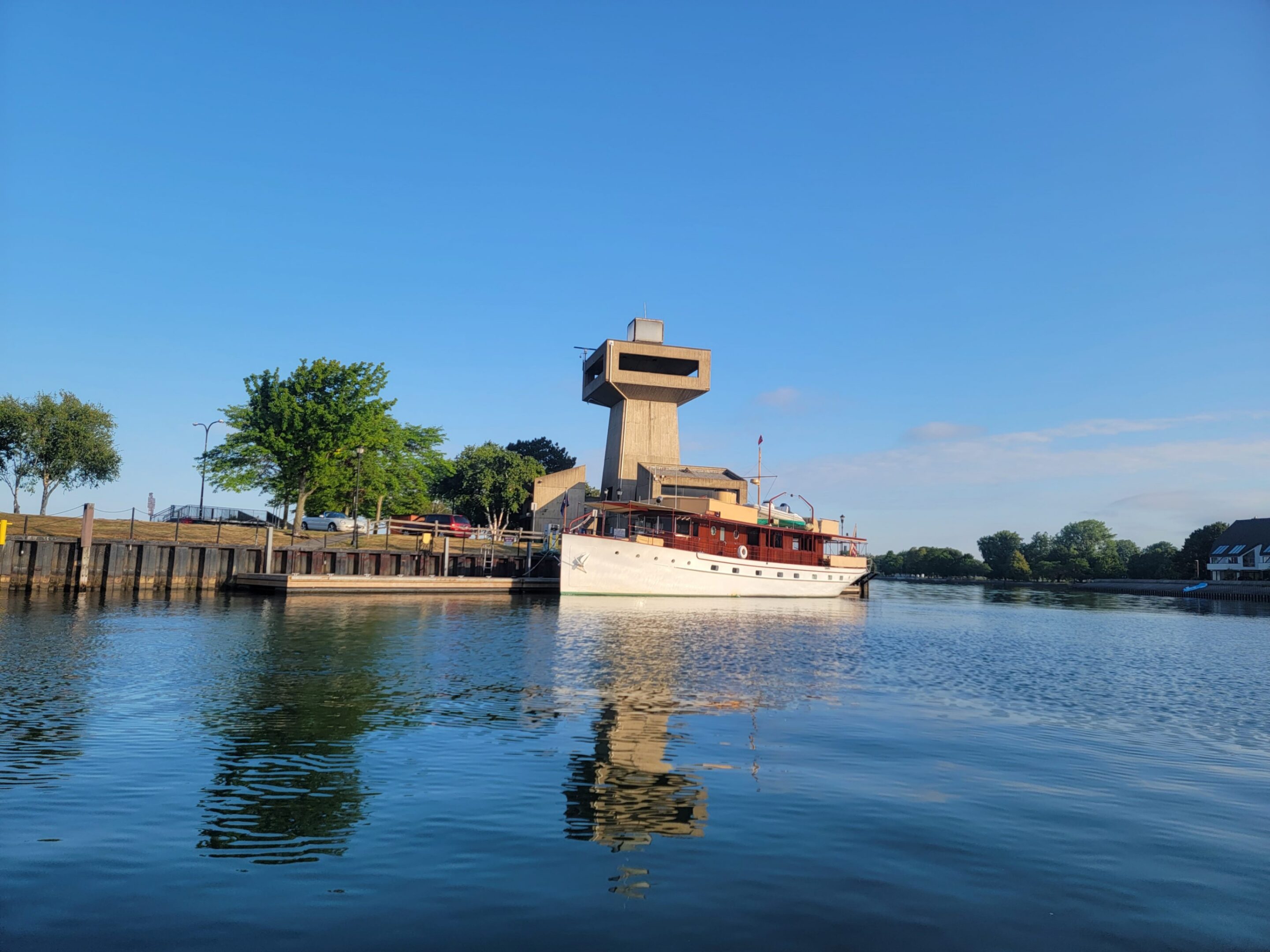 White yacht docked by waterfront observation tower